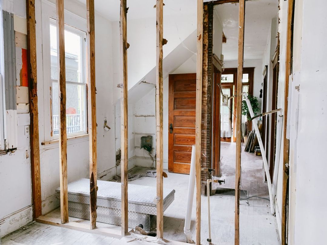 Innenraum eines Hauses in Sanierung mit freiliegenden Holzbalken und alter Tür